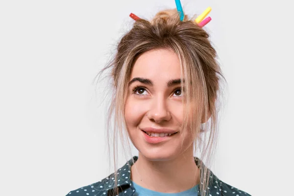 Horizontal close up tiro de jovem com cabelo selvagem e marcadores coloridos no cabelo, sorrindo e olhando para o texto de publicidade, na parede branca . — Fotografia de Stock