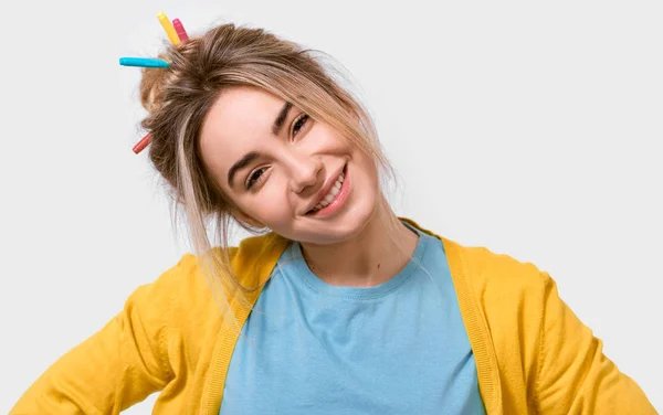 Mulher jovem caucasiana atraente em blusa amarela e camiseta azul, com marcadores coloridos no cabelo, sorrindo amplamente e olhando para a câmera, isolada sobre fundo branco. Pessoas emoções — Fotografia de Stock