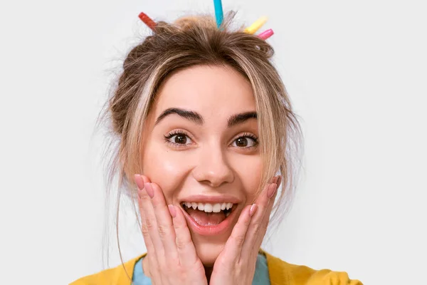 Feche o retrato da jovem surpresa feliz que sorri largamente, mantém faces à mão. Mulher bonita ouve algo agradável, mantém as mãos nas bochechas, isolado sobre fundo branco — Fotografia de Stock