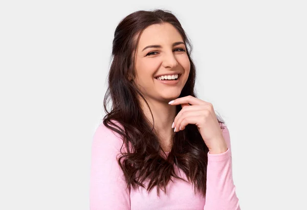 Isolated close up studio image of happy young woman, smiling broadly, wears pink long sleeve blouse. Caucasian brunette female in pink blouse posing over white studio wall. People and emotion concept — Stock Photo, Image