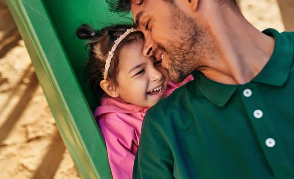 Retrato de close-up de feliz menina bonito filha sorrindo e brincando com seu pai ao ar livre. Bonito pai e criança menina se divertindo e brincando no playground. Pai e filha compartilham o amor — Fotografia de Stock