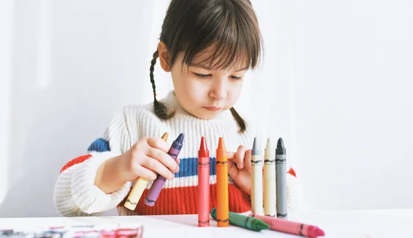 Lindo niño jugando con lápices de colores en casa. Chico feliz dibujando sobre papel en el jardín de infantes. Concepto de personas, infancia y educación — Foto de Stock