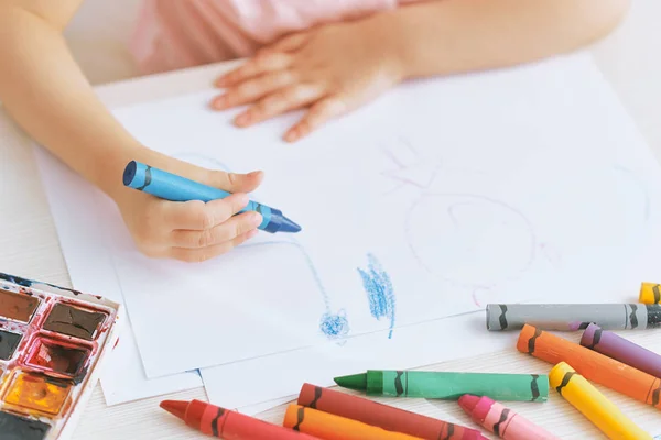 Обрезанное изображение маленькой девочки с красочными карандашами. Милый ребенок делает смешные изображения на бумаге за столом, в детском саду. Человек, детство, образование — стоковое фото