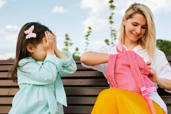 Mooie dochter bedekt haar ogen terwijl haar moeder een verrassing buiten doet. Happy Mothers Day! Cheefrul jonge vrouw glimlachend en spelen met haar kind in het Park. Familie vakantie en saamhorigheid — Stockfoto