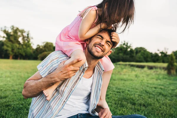 Imagem ao ar livre de pai engraçado passar um bom tempo junto com sua filha bonita. Feliz linda menina brincando com o pai no parque. Feliz Dia do Pai. Papai e filha compartilham amor. Paternidade — Fotografia de Stock