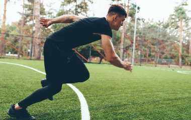 Parkta yeşil çim üzerinde çalışan sağlıklı genç adam tam uzunlukta yatay görüntü. Sağlıklı erkek koşucu açık havada koşuyor. Genç erkek koşucu spor sahasında çalışıyor. Spor ve insanlar.