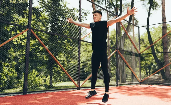 Jovem atlético musculoso fazendo core workout no sportsground. Exercícios masculinos de fitness caucasiano exercitando-se ao fundo da luz solar. Pessoas e conceito de desporto — Fotografia de Stock