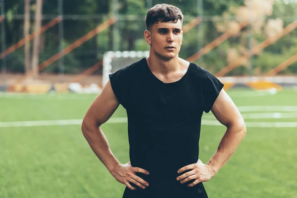 Portrait of healthy young man standing outdoors in the park and looking away, with hands on the waist, preparing for workout training. Confident young fitness man ready of workout. People and sport. — Stock Photo, Image