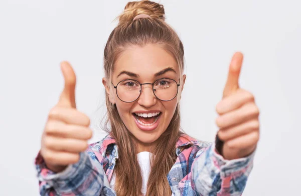 Gelukkige jonge vrouw glimlacht breed en maakt duimen omhoog, toont haar steun en respect. Mooie blanke vrouw die positief gebaar maakt. Lichaamstaal. Goed gedaan. — Stockfoto