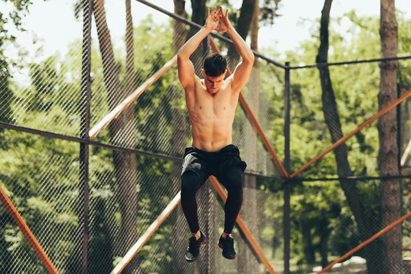 स्नायू तरुण माणसाचे प्रशिक्षण आणि धावण्यापूर्वी उडी मारण्याची बाहेरची प्रतिमा. क्रीडा, जीवनशैली आणि लोक संकल्पना . — स्टॉक फोटो, इमेज