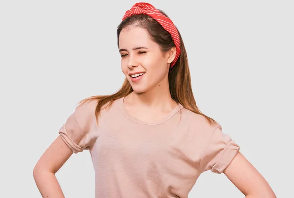 Estúdio retrato de jovem feliz, piscando com o olho, sorrindo positivamente vestindo camiseta bege e cabeça vermelha, olhando para a câmera, isolado em fundo cinza. Pessoas emoções — Fotografia de Stock