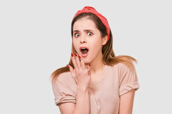 Escolchoado bela jovem mulher tem espantado expressão. Retrato de fêmea muito surpreso, segurando a mão na boca com unhas vermelhas, parecendo surpreso posando sobre fundo branco. Pessoas emoções — Fotografia de Stock