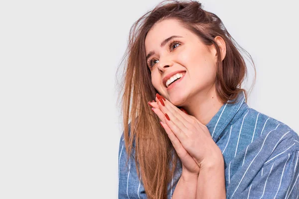 Closeup portrait of happy young woman touching her perfect soft face skin with hands, looking aside, posing in studio. Pretty female has pleasant expression. People, beauty and healthcare concept — Stock Photo, Image