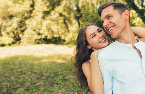 Outdoor portrait of romantic couple in love dating outdoors at the park on a sunny day. Happy couple in love embracing each other, looking with love having eyes full of happiness. Date day. Valentine — Stock Photo, Image