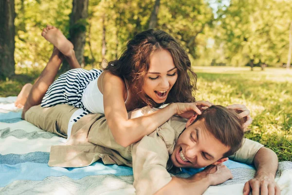 Couple joyeux amoureux, datant à l'extérieur au parc par une journée ensoleillée. Couple heureux allongé sur l'herbe pendant le pique-nique, s'amusant, dans le fond de la nature. Saint Valentin. Bonne relation — Photo