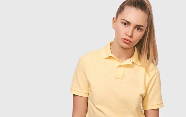 Vacker allvarlig blond ung kvinna med frisk ren hud i gul t-shirt tittar på kameran med lugn uttryck. Attraktiv hona med naturlig frisk hud — Stockfoto