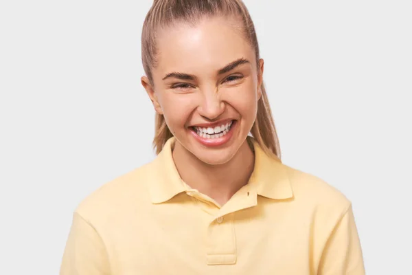 Close-up retrato de uma jovem mulher feliz, sorrindo ampla e positivamente vestindo roupas amarelas casuais e olhando para a câmera, isolado no fundo do estúdio branco. Conceito de pessoas e emoções — Fotografia de Stock
