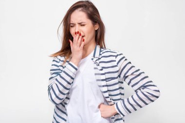 Yorgun ve overworked genç iş kadını esneme, rahat kıyafet giyiyor, beyaz stüdyo arka plan üzerinde izole. Pretty öğrenci kadın duygu uykuda. 