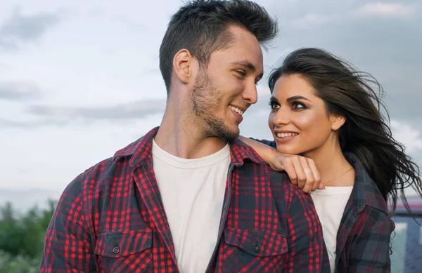 Beautiful happy couple have dating in the park showing a happy relationship goals. Handsome Caucasian man wearing casual shirt with smiling girlfriend hugs him. Lifestyle, people and travel concept.