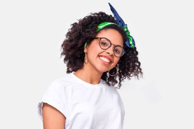 Güzel mutlu koyu tenli genç kadın beyaz t-shirt giymiş, hava zevk. Afro-Amerikan kadın geniş gülümseyerek, yuvarlak gözlük beyaz stüdyo duvar üzerinde poz giyiyor