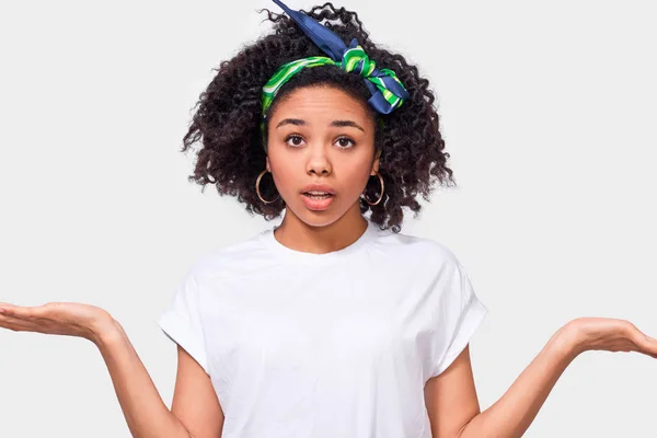 Verbaasd Afro-Amerikaanse jonge vrouw schouderophalend schouders, ziet er onzeker, verward met open handpalm, heeft twijfels. Donker gevild vrouwtje kan geen choise maken. Mensen emoties en gevoelens concept. — Stockfoto