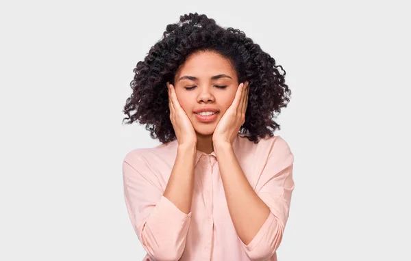 African American young woman touching her head with closed eyes wearing  pink shirt. Afro female student dreaming. Health concept — Stock Photo, Image