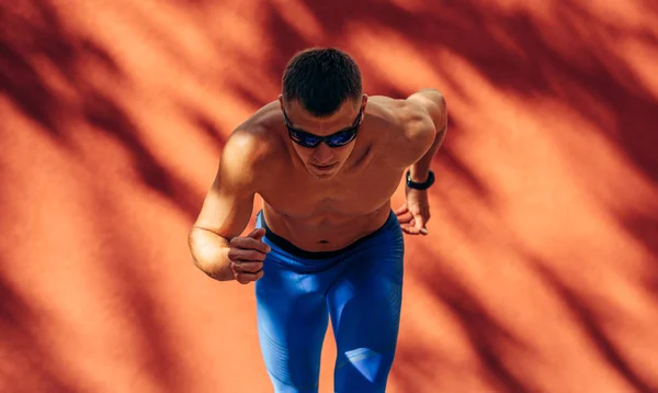 Homme athlétique se préparant à courir. Sportsman, sprint de coureur masculin pendant la séance d'entraînement pour la compétition. Personnes, sport et mode de vie sain — Photo
