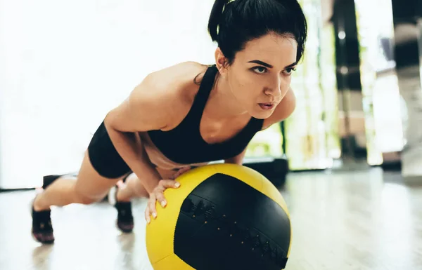 건강 한 여성 이 메디신볼 을 사용하여 운동하는 모습을 확대 한 사진입니다. 여자 운동 선수 가 체육관에서 의료 볼을 들고 스트레칭합니다. 스포츠와 사람들의 개념 — 스톡 사진