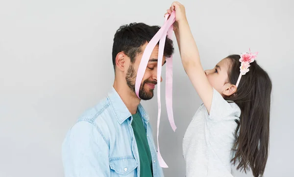 Lovely Daughter Puts Father Pink Ribbon Gift His Head Isolated — Stock Photo, Image