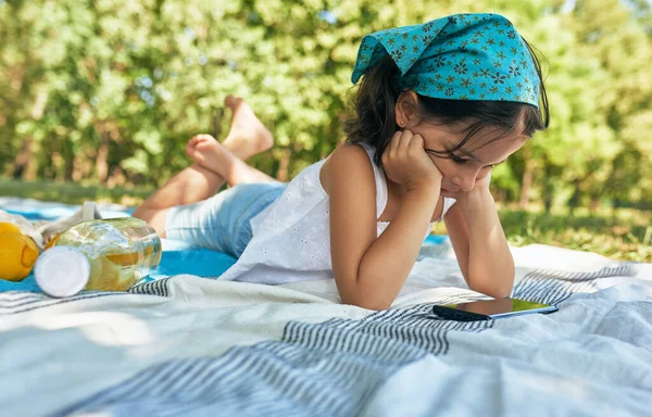 Horizontal Outdoor Image Cute Little Girl Lying Blanket Watching Cartoons — Stock Photo, Image