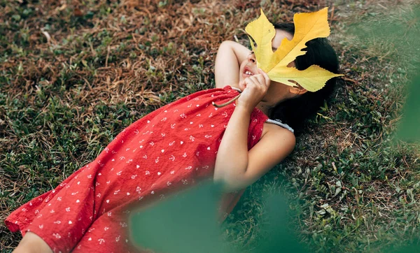 Vista Superior Menina Bonito Segurando Sua Mão Grande Folha Amarela — Fotografia de Stock