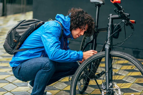 Homem Encaracolado Jovem Que Fixa Com Sua Bicicleta Depois Andar — Fotografia de Stock