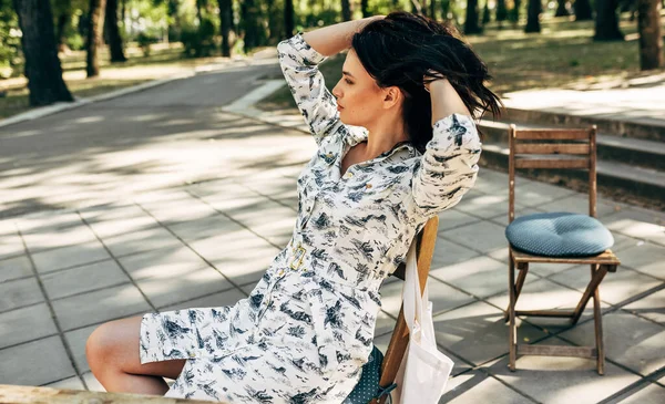 Güzel genç bir kadın caddedeki teras kafede mola veriyor. Güneşli bir günde parkta dinlenen güzel kız..