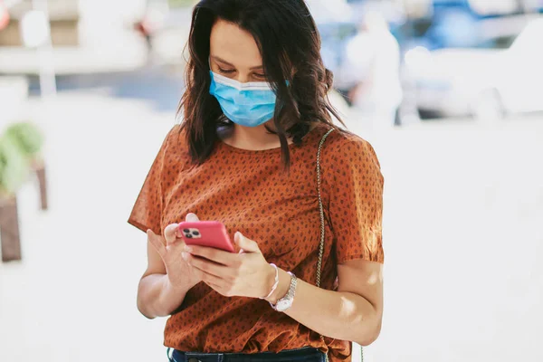 Forretningskvinne Brunette Med Beskyttende Maske Pandemien Hun Ser Mobilen Sin stockfoto