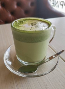 Bir cam fincan sıcak yeşil çay matcha latte