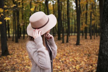 Sonbahar Parkı 'nda yürüyen açık renk şapkalı kız.