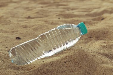 Tatil kavramı. İçme suyu deniz plajın kumları üzerinde plastik şişe