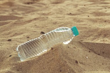 PET şişe çölde su ile. Bir şişe su sıcak çölde kum yalan