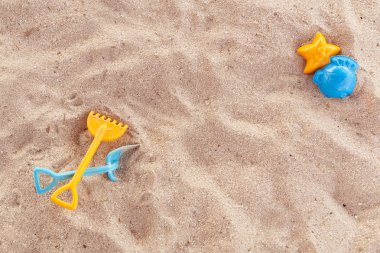 Parlak plastik çocuk oyuncakları kum. Çocuklar için plaj rekreasyon kavramı. Çocuk yaz oyunları. Yaz konsepti. Düz yatıyordu, en iyi görünüm, kopya alanı, mavi ve sarı.