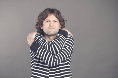 Portre kendini gri duvar arka plan üzerinde izole sarılma tutarak emin gülümseyen adam portresi. Olumlu insan duygu, yüz ifadesi. Love kendinizi kavramı.