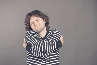 Kendini sarılırsan kız gerekmez. Bencil feeling kavramı. Kendini sarılma ve zevk, gülümseyen beyaz gömlekli komik beyaz adam gözlerini kapatma.