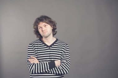 Stüdyo boş duvara geçti ve düşünceli ifade, hafta sonu için planlar ile seyir silah tutmak, poz hacimli saçlı dalgın genç Avrupa erkeği olarak vurdu. Beden dili.