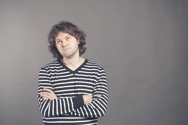 Portrait of caucasian man with bored fed up expression, looks displeased up, being tired to explain his wife where he was at night. Shaggy guy in stripes shirt tired and bored to listen to bullshit.