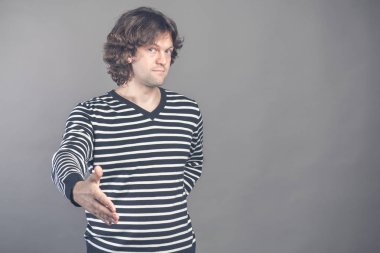 Hoş geldiniz, sizi görmek ne güzel. Kameraya el sıkışma sunan elini ulaşan ile seyir siyah ve beyaz çizgili kazaklı adam. Kapalı studio vurdu. Merhaba, jest tebrik. İnsan duygu ve işaretleri