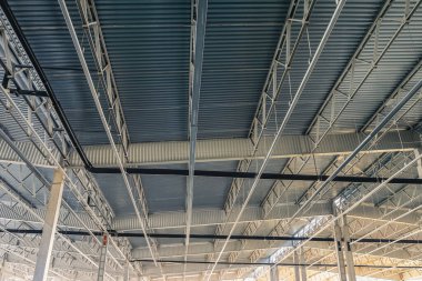 Binanın iç yapısına bakıyorum. Metal kirişler, eğri büğrü metal çatı ve yapısal iskelet..