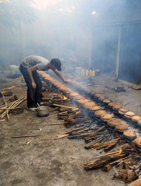 Hanam, Vietnam, 26 Ocak 2019: İşçiler kil tencereyle balık pişirir. Bu Vietnam 'ın ünlü balık işleme metodudur.