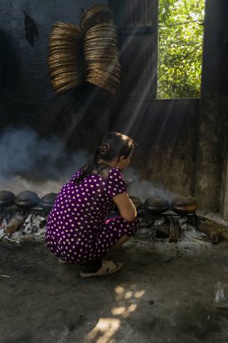 Hanam, Vietnam, 26 Ocak 2019: İşçiler kil tencereyle balık pişirir. Bu Vietnam 'ın ünlü balık işleme metodudur.