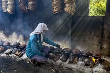 Hanam, Vietnam, 26 Ocak 2019: İşçiler kil tencereyle balık pişirir. Bu Vietnam 'ın ünlü balık işleme metodudur.