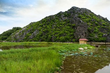 Vietnam kırsalında gün batımında dağlar ve çayır zulası