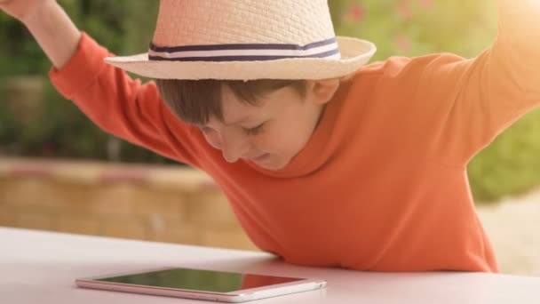 Little boy playing with tablet on summer nature background — Stock Video